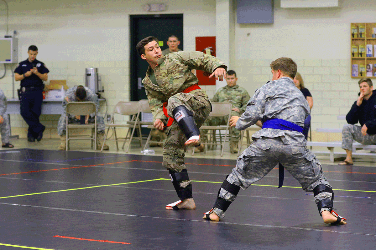Soldiers compete on mats.