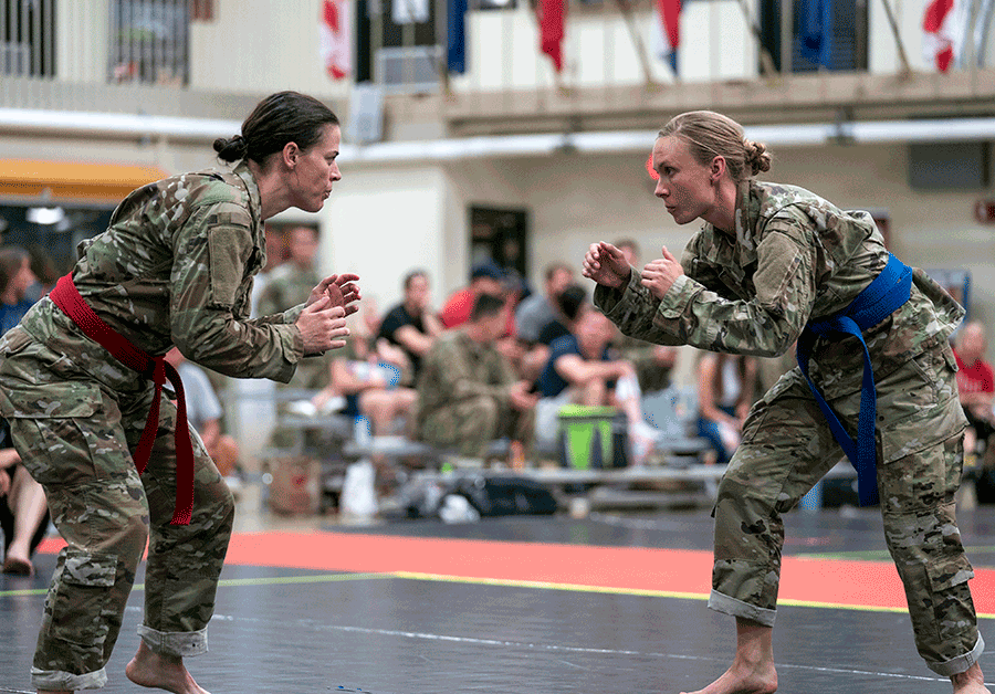 Two Female Soldiers face off on mat.
