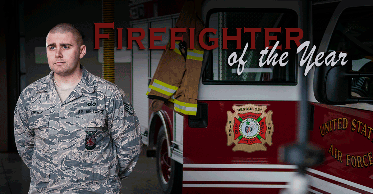 Staff Sgt. Michael Ginikos, in Air Guard camo, stands in front of firetruck.