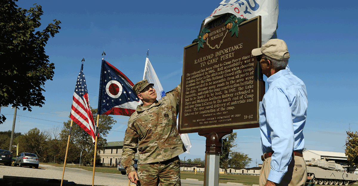 Col. Daniel Shank and Burt Logan unveil a historic marker.
