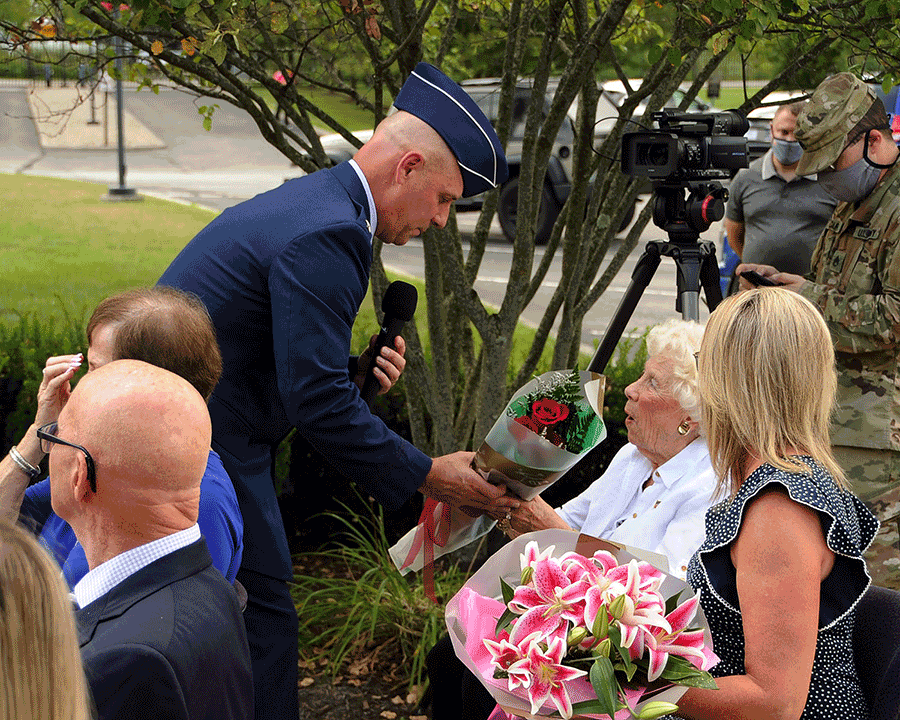 Brig. Gen. Gary McCue  presents flowers to his mother and wife.