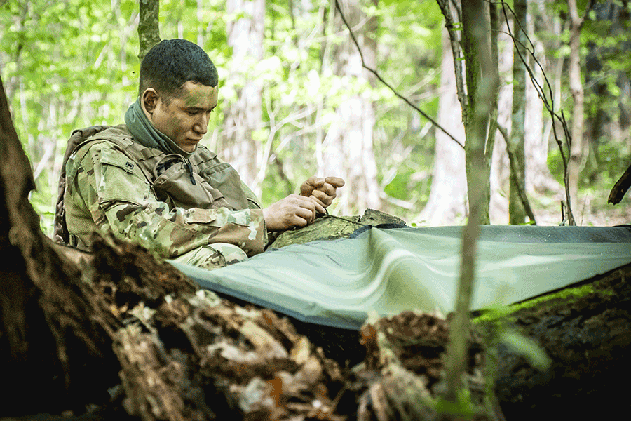Airman builds shelter in woods.