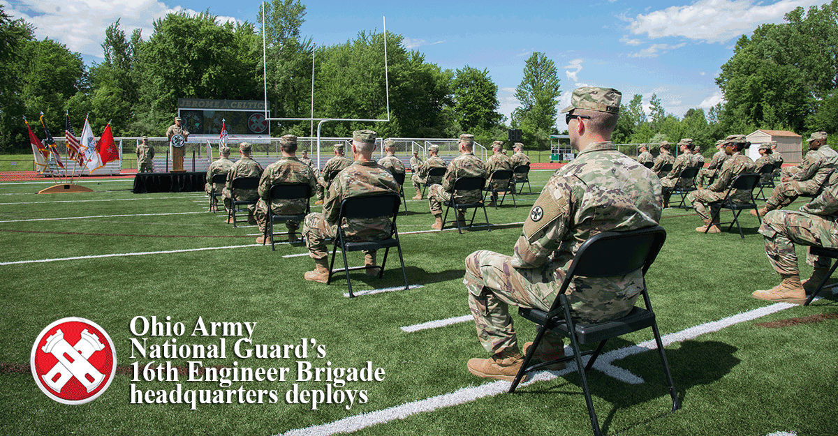 Guard memebr sit socially distanced on football field for call to dty ceremoy.