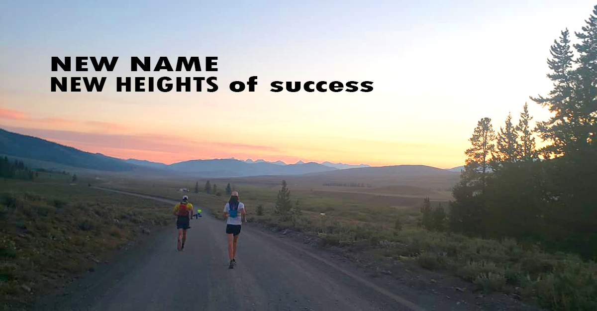 Team running on dirt road at sunrise with mountains in distance.