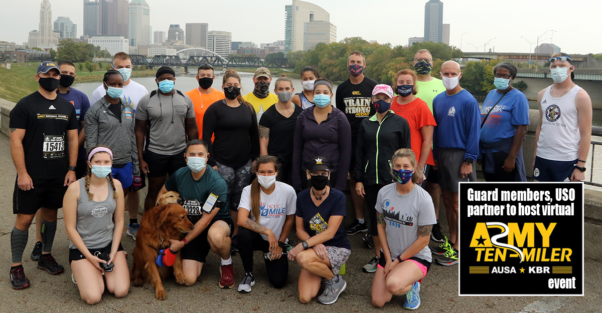Runners gather for a group photo with Columbus skyline in background.