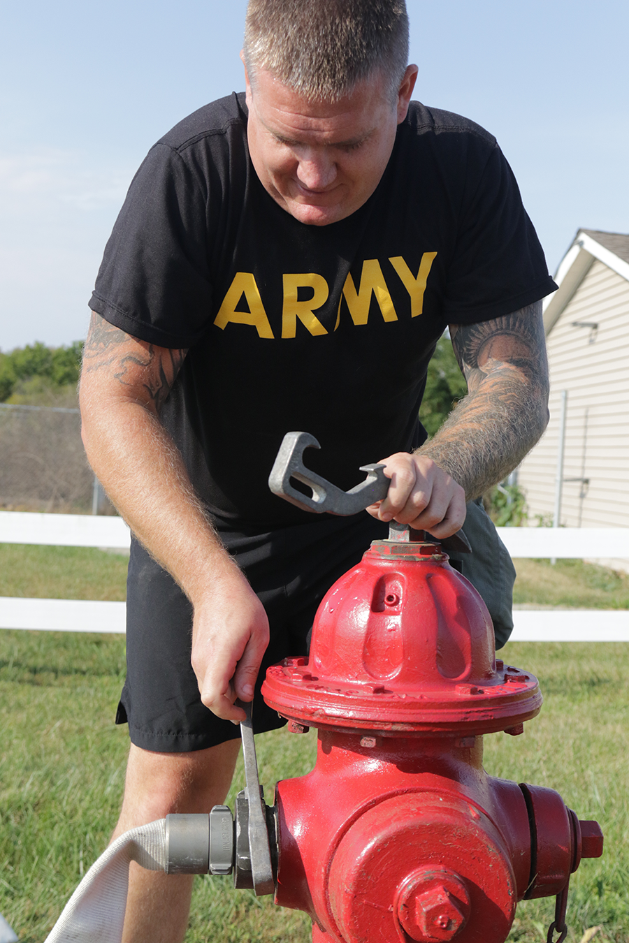 Sgt. 1st Class Ryan Menth hooks up a hose to a fire hydrant.