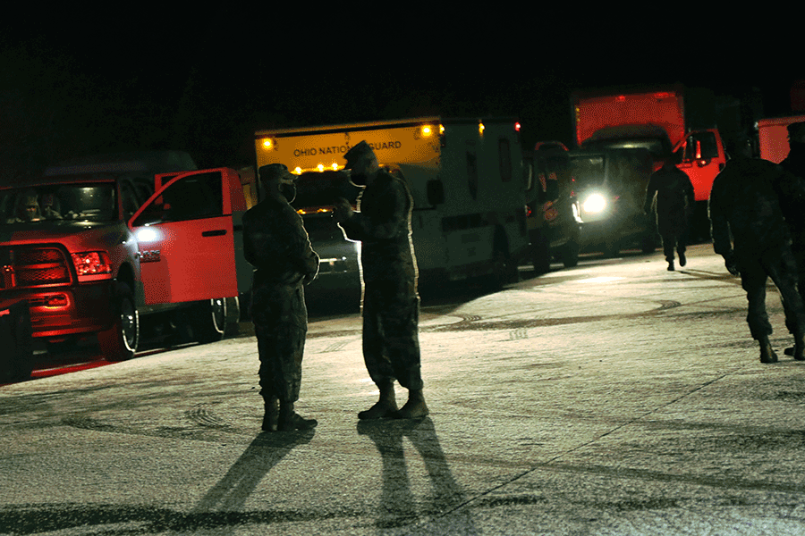Night shot of vehicles with lights in caravan.