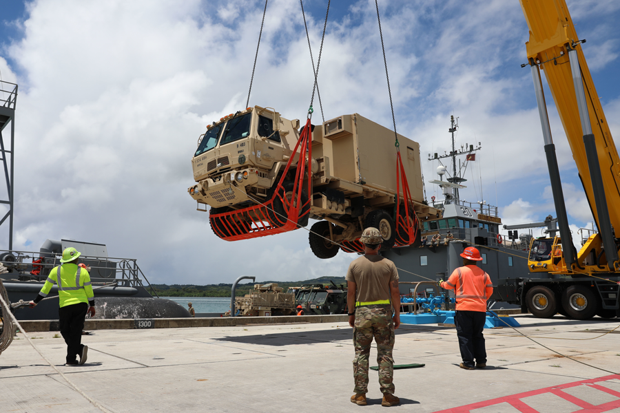 Soldiers and civilian contract workers load a Light Medium Tactical Vehicle onto Army Watercraft System.
