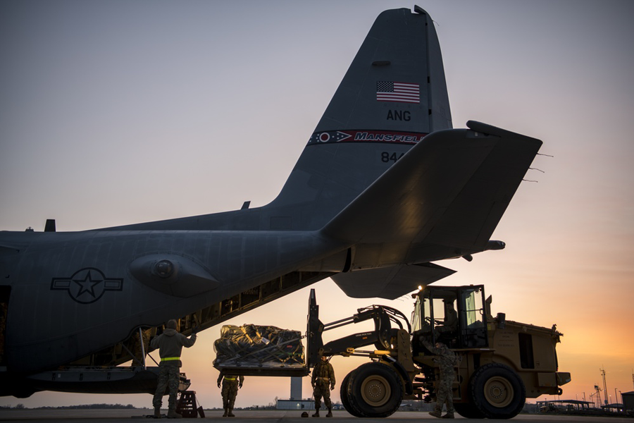 Cargo being loaded into the back of an ONG aircraft at sunset.