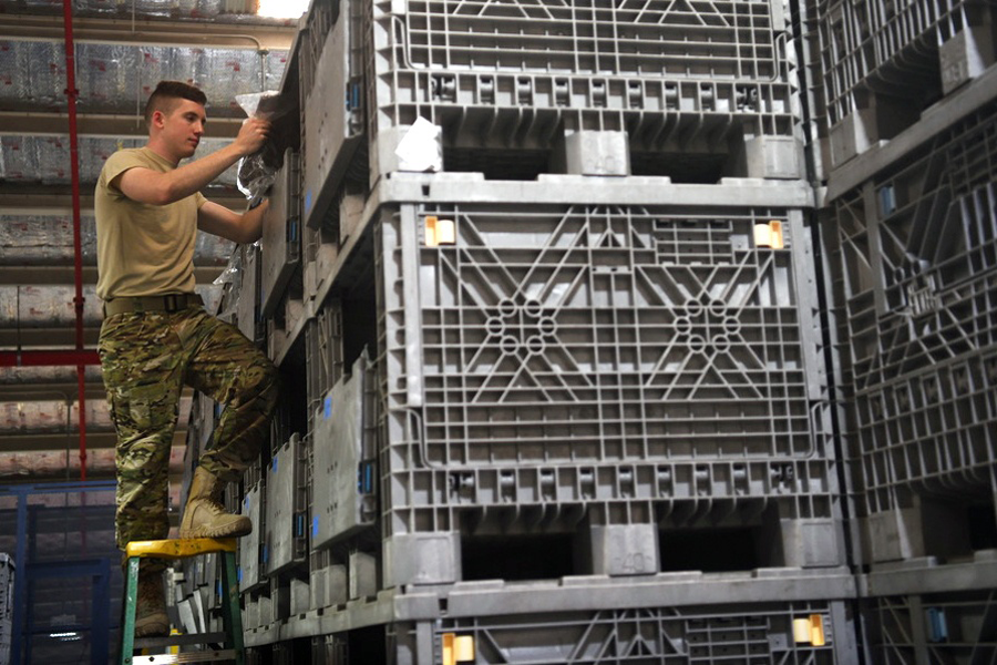 Airman on ladder looking at cargo.