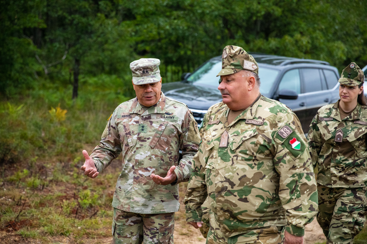 Maj. Gen Harris walks with Hungarian leaders in field.
