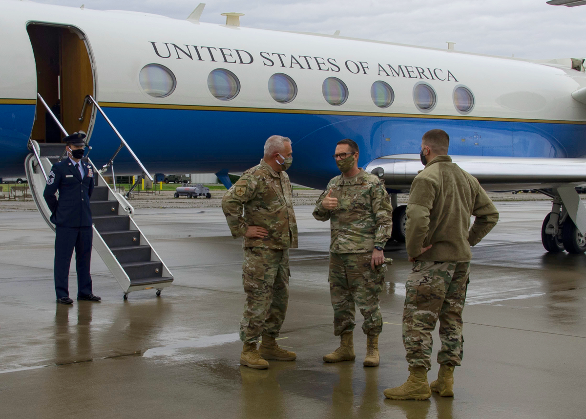 Chief Master Sgt. Troy Taylor talks with other guard members on tarmac under Air Force One