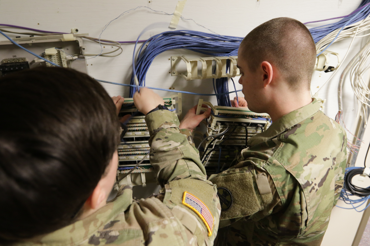 Two Soldiers working onnetwork cables.