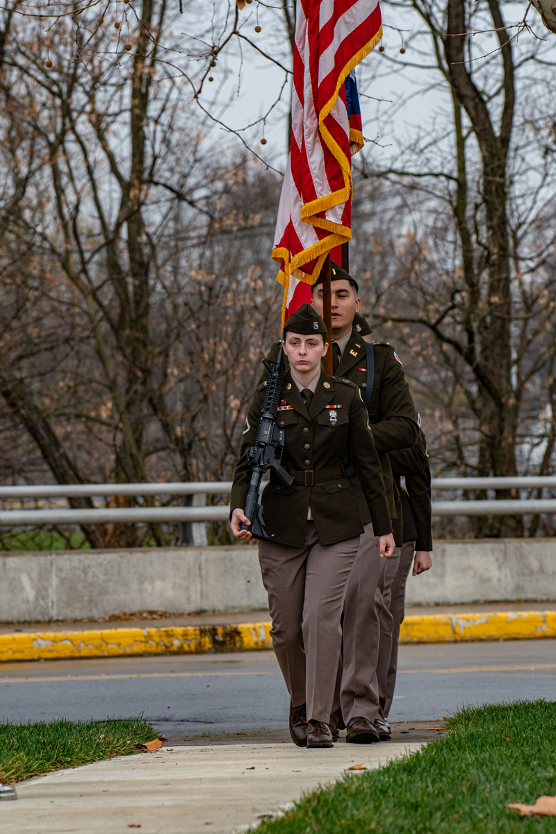 Color Guard in formation coming up sidewalk in winter.
