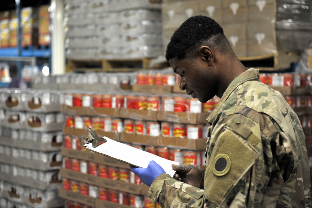Soldier looks over chart in pantry