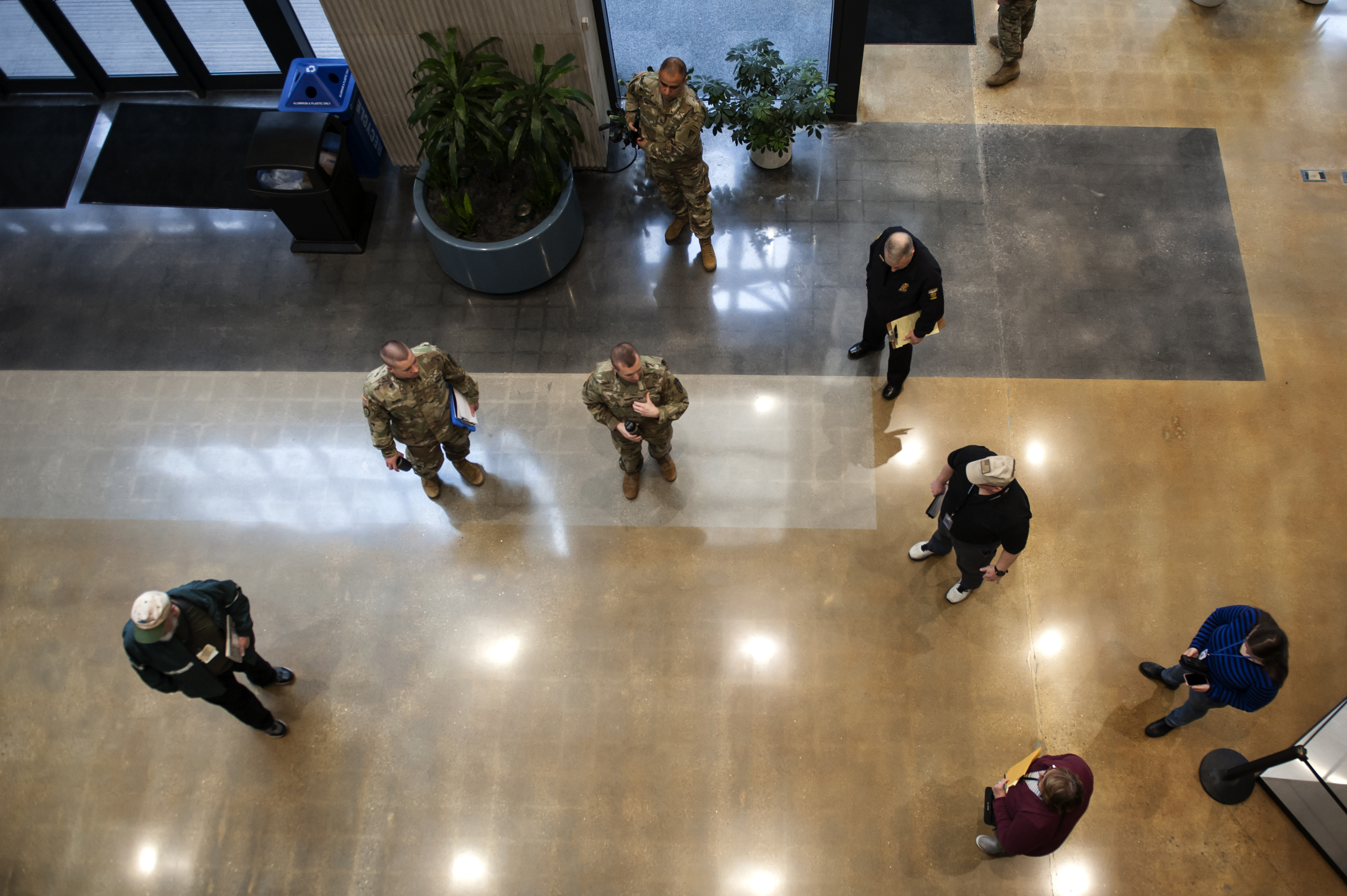 Soldiers and regional management in lobby as seen from above.