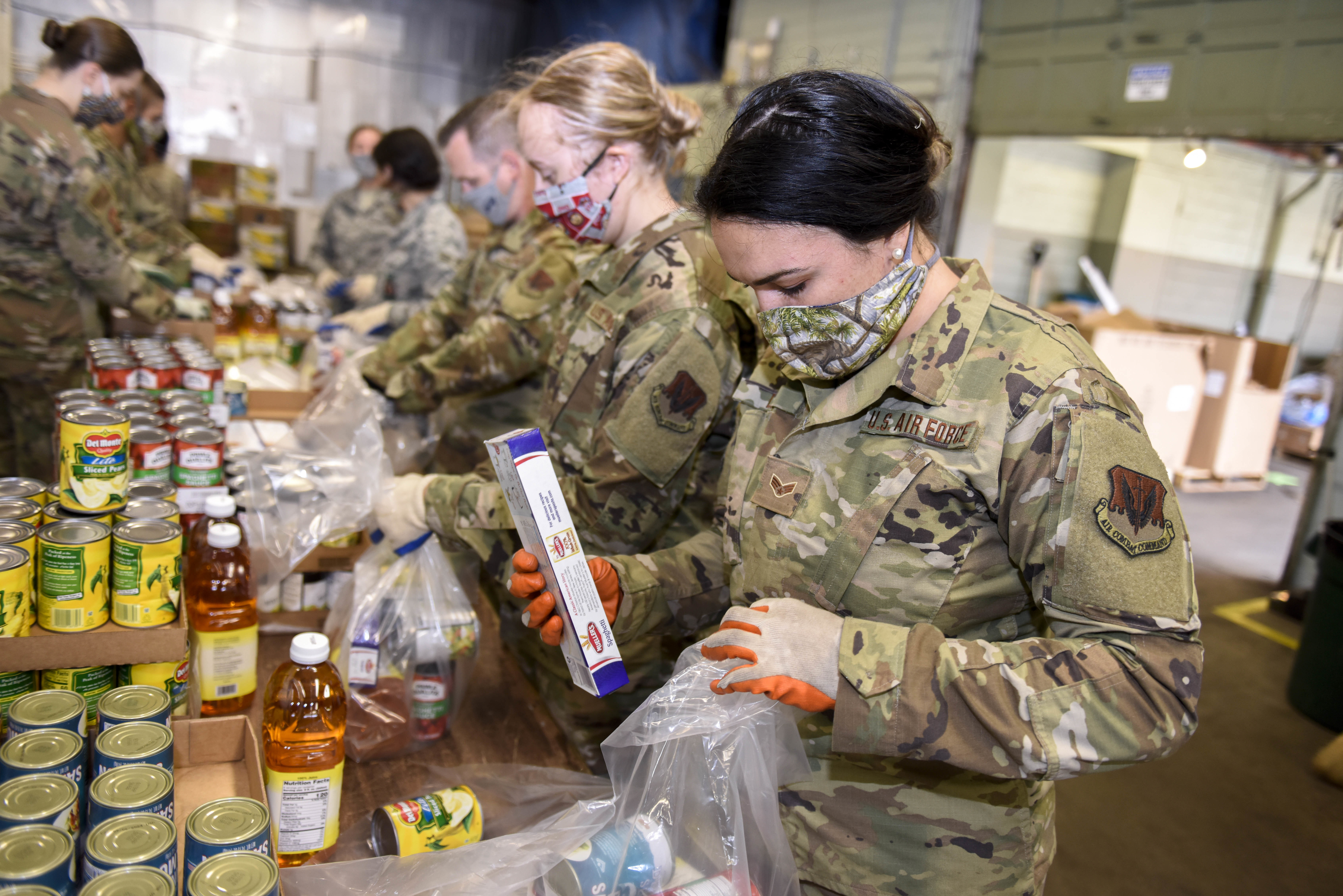 Soldiers packaging food bundles.