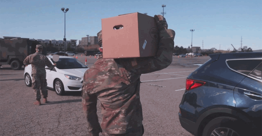 Soldiers carry boxes to drive through cars