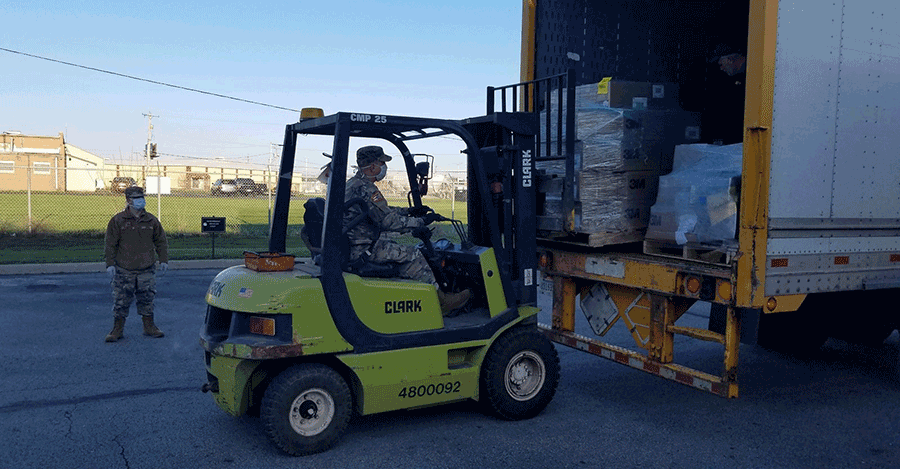 Soldier uses forklift to load truck.