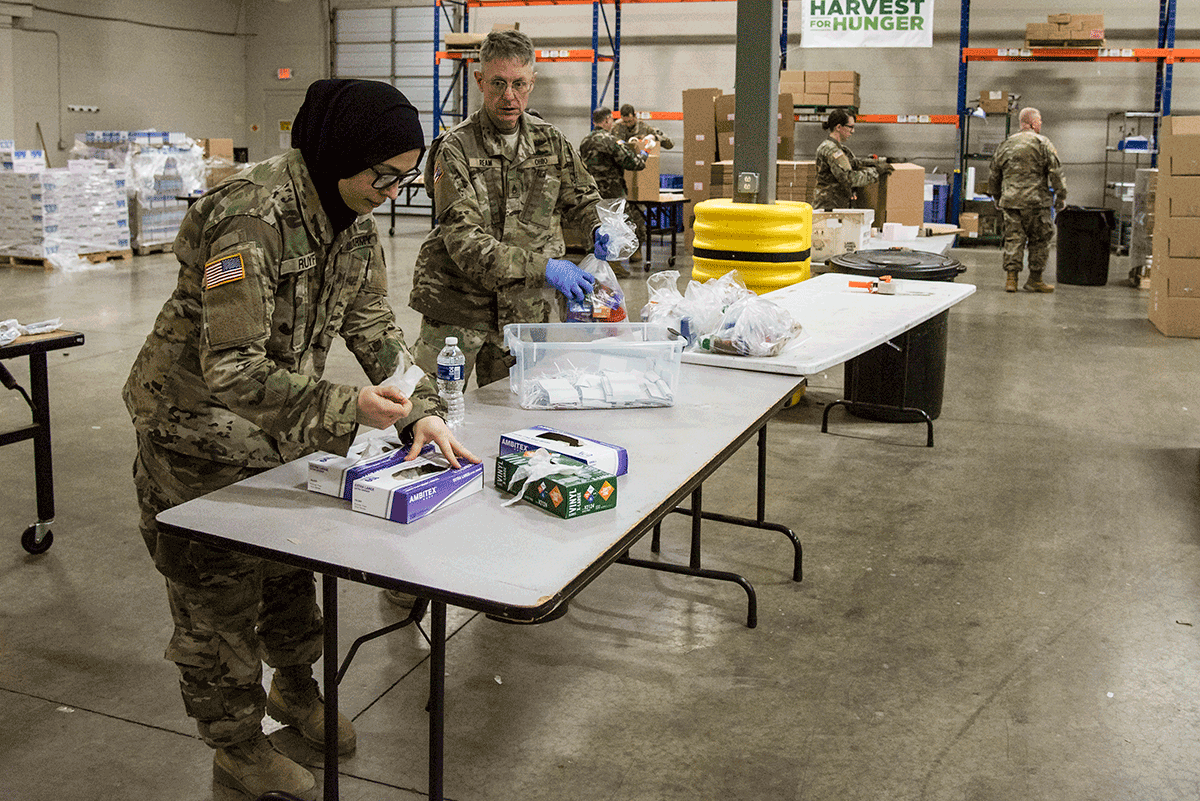 Soldiers working in warehouse. 