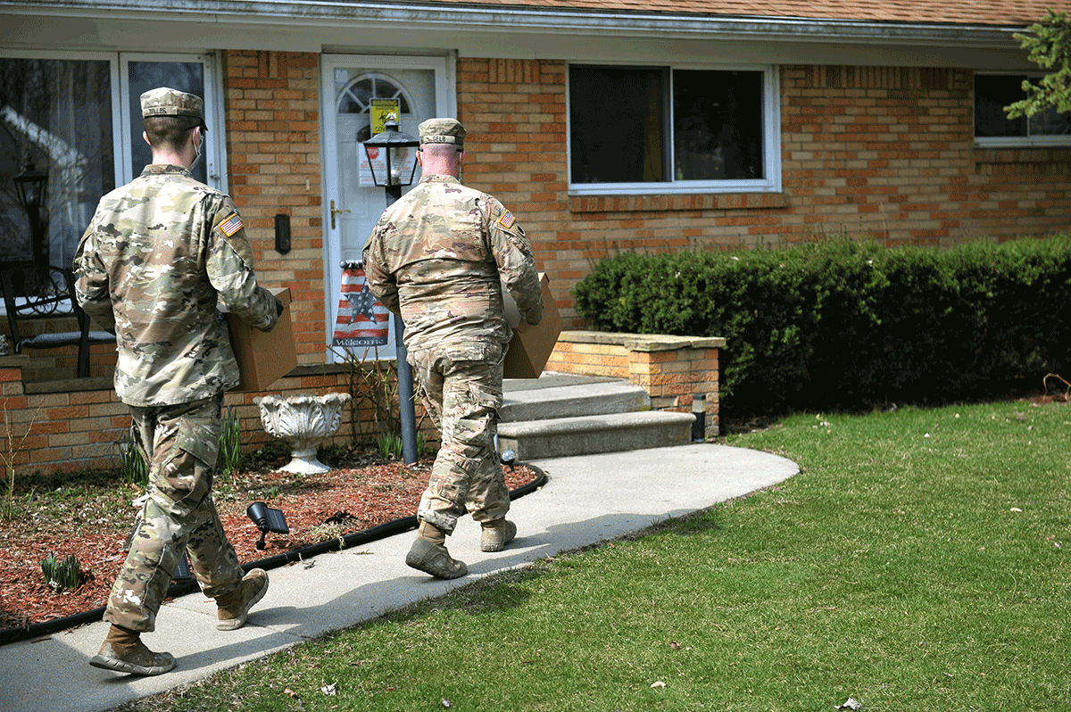 Soldiers carry boxes of supplies to front door of Ohioan in need.
