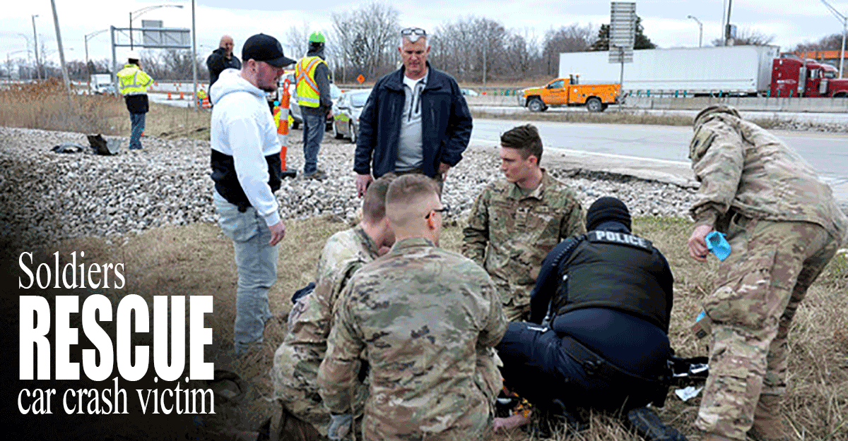 Ohio Army National Guard Soldiers are alonside road with police and others tending to casualty.