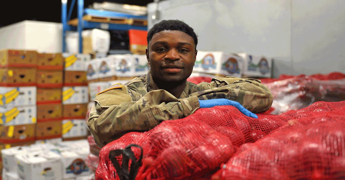Spc. Jacque Elama stands for photo at food bank.