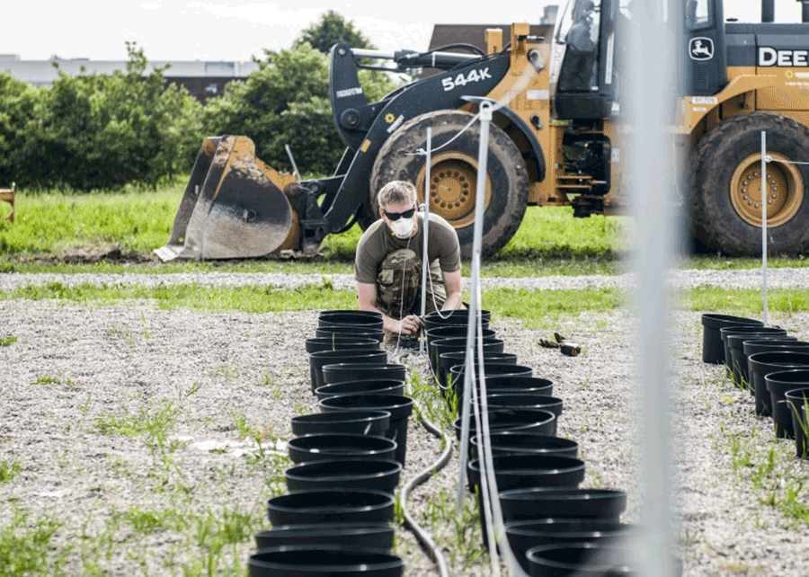 Soldier runs cables between posts.