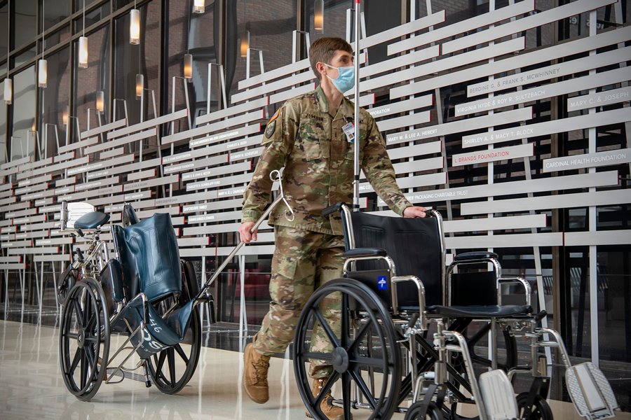 Male Guard member transports wheelchairs 