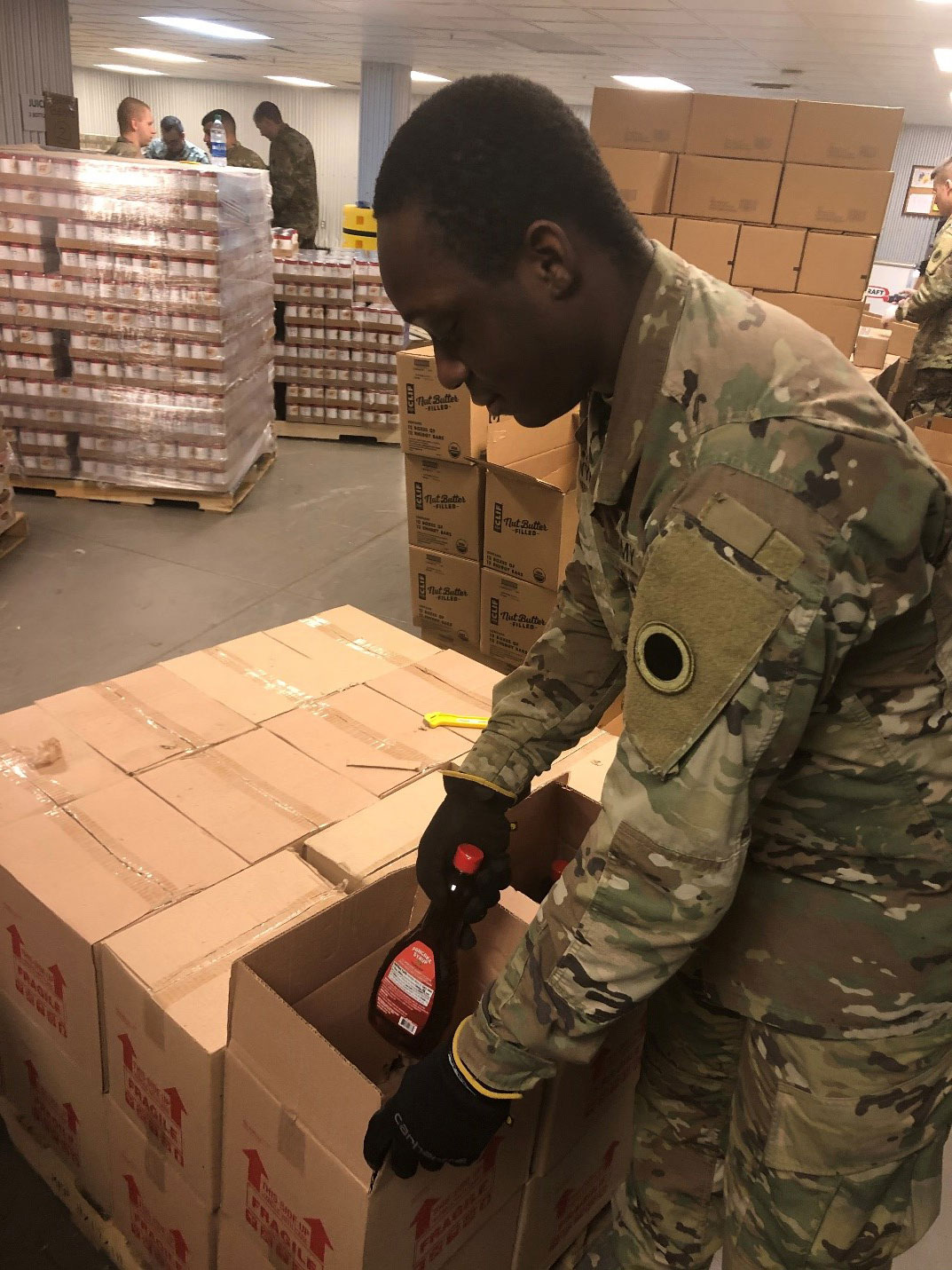 Soldier loads syrup into box.