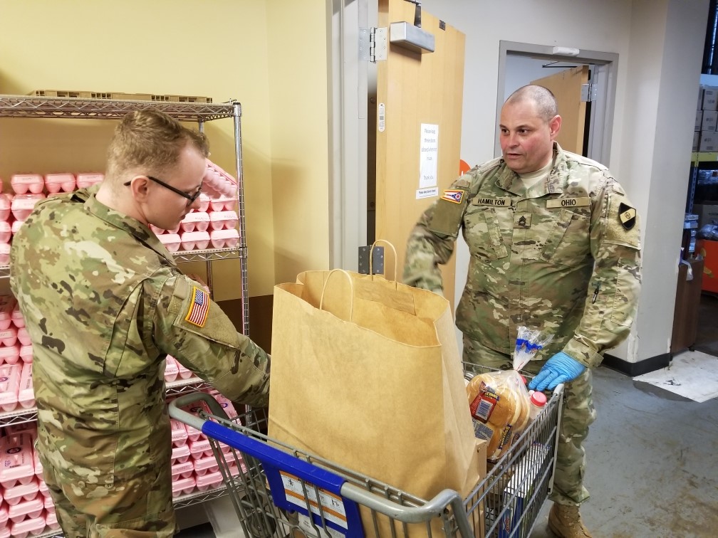 Soldiers load grocery cart.