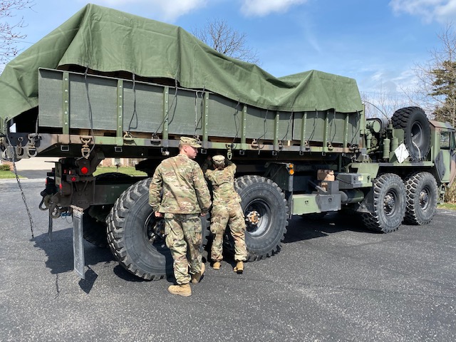 Soldiers prepare to unload trailer from truck.