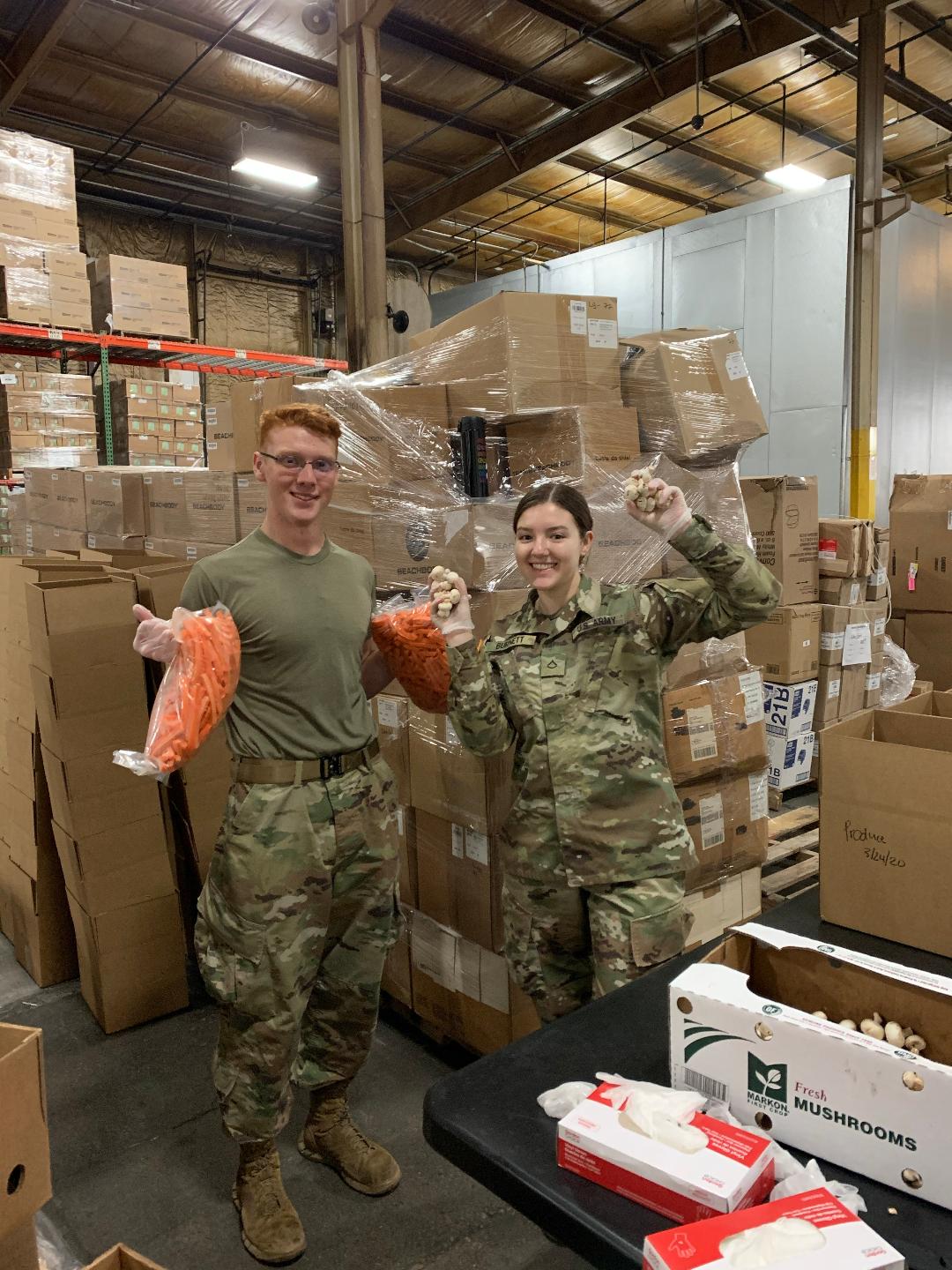 Soldiers load boxes with produce.