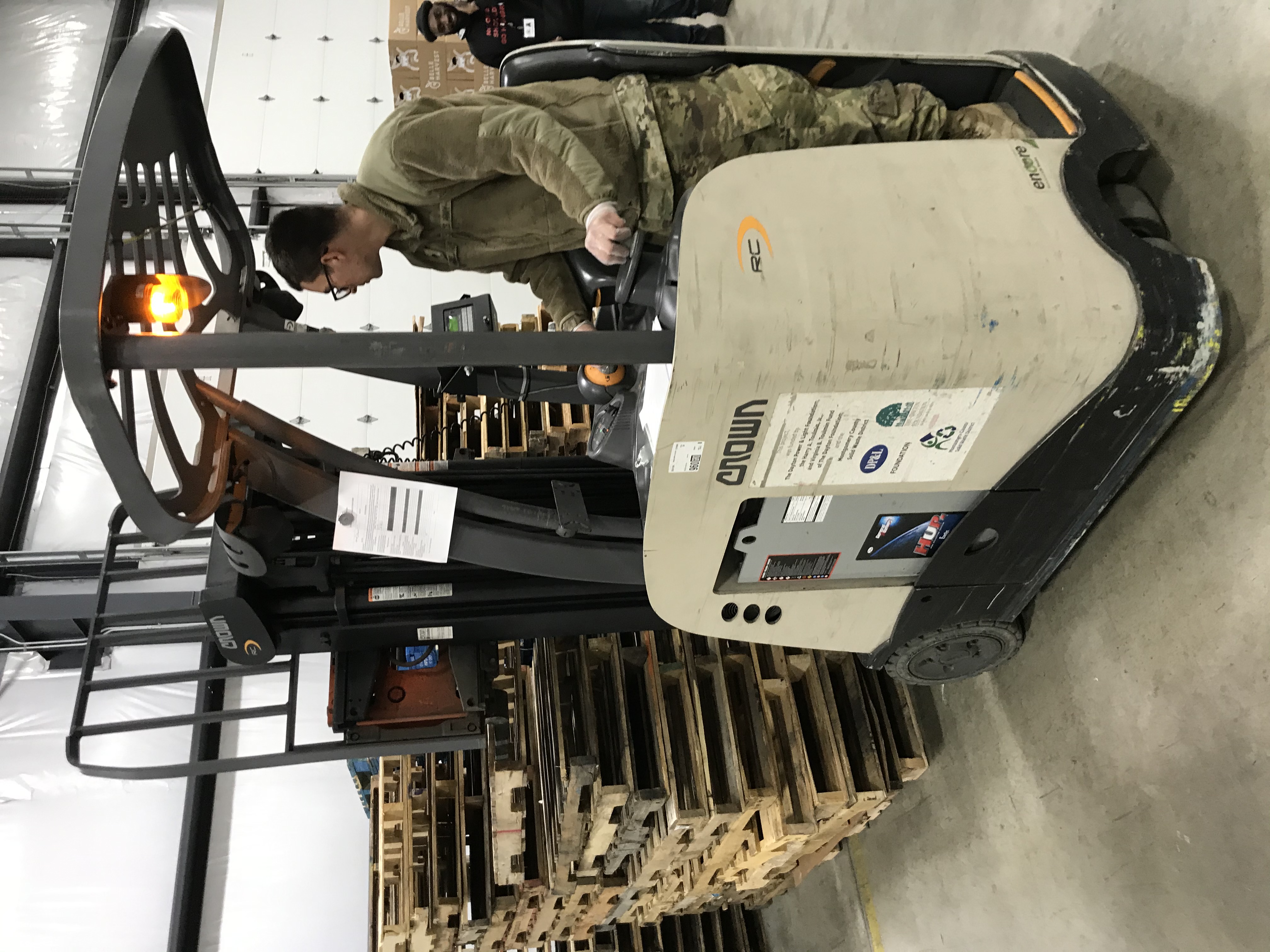 Soldier moves pallets inside warehouse.