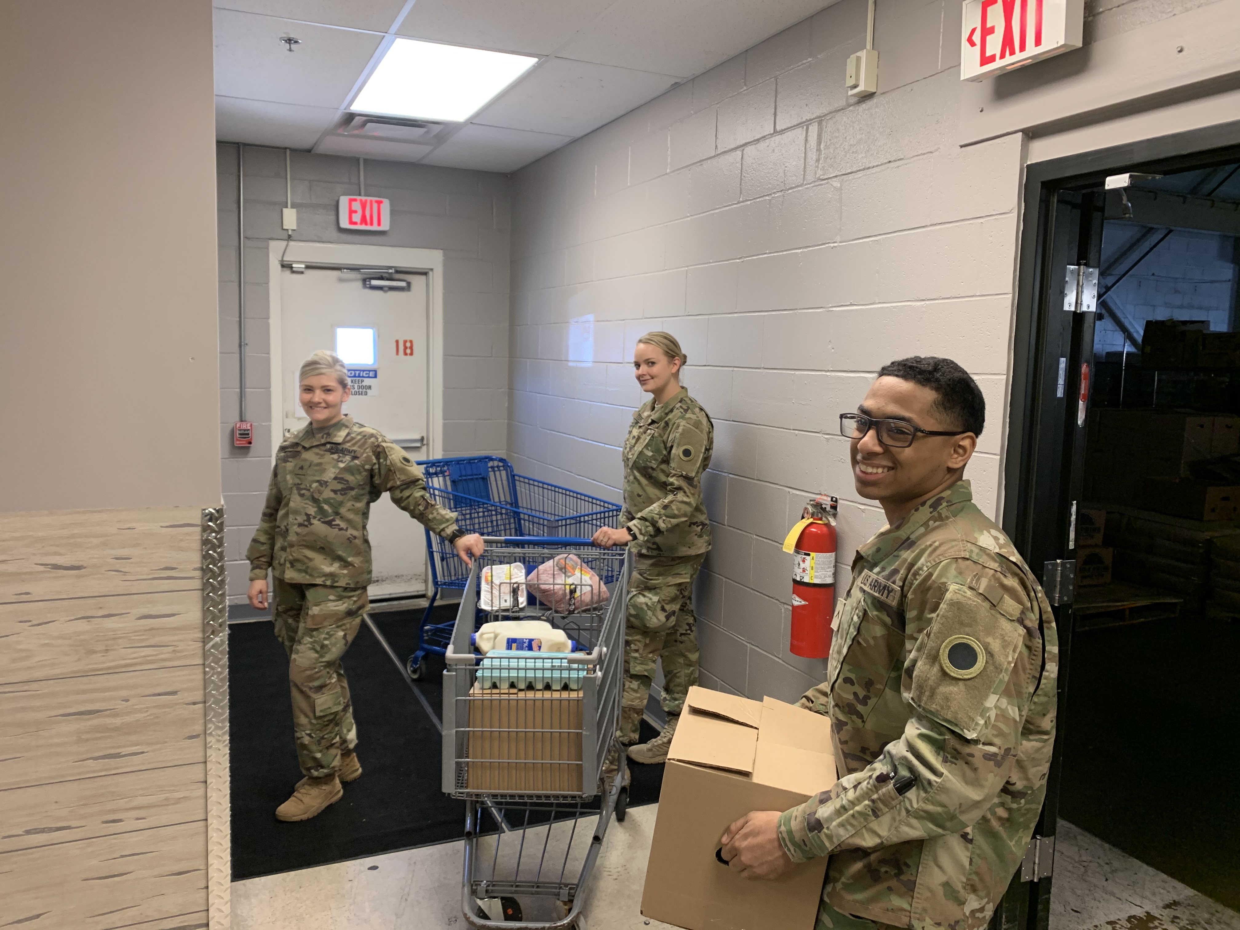 Soldiers pack carts in warehouse.